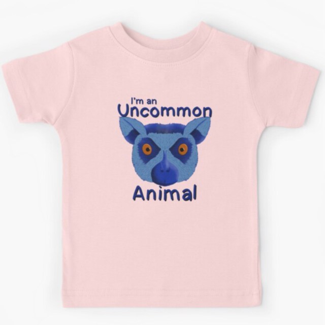 Pink kids' t-shirt featuring a vibrant blue ring-tailed lemur illustration with the text "I’m an Uncommon Animal."